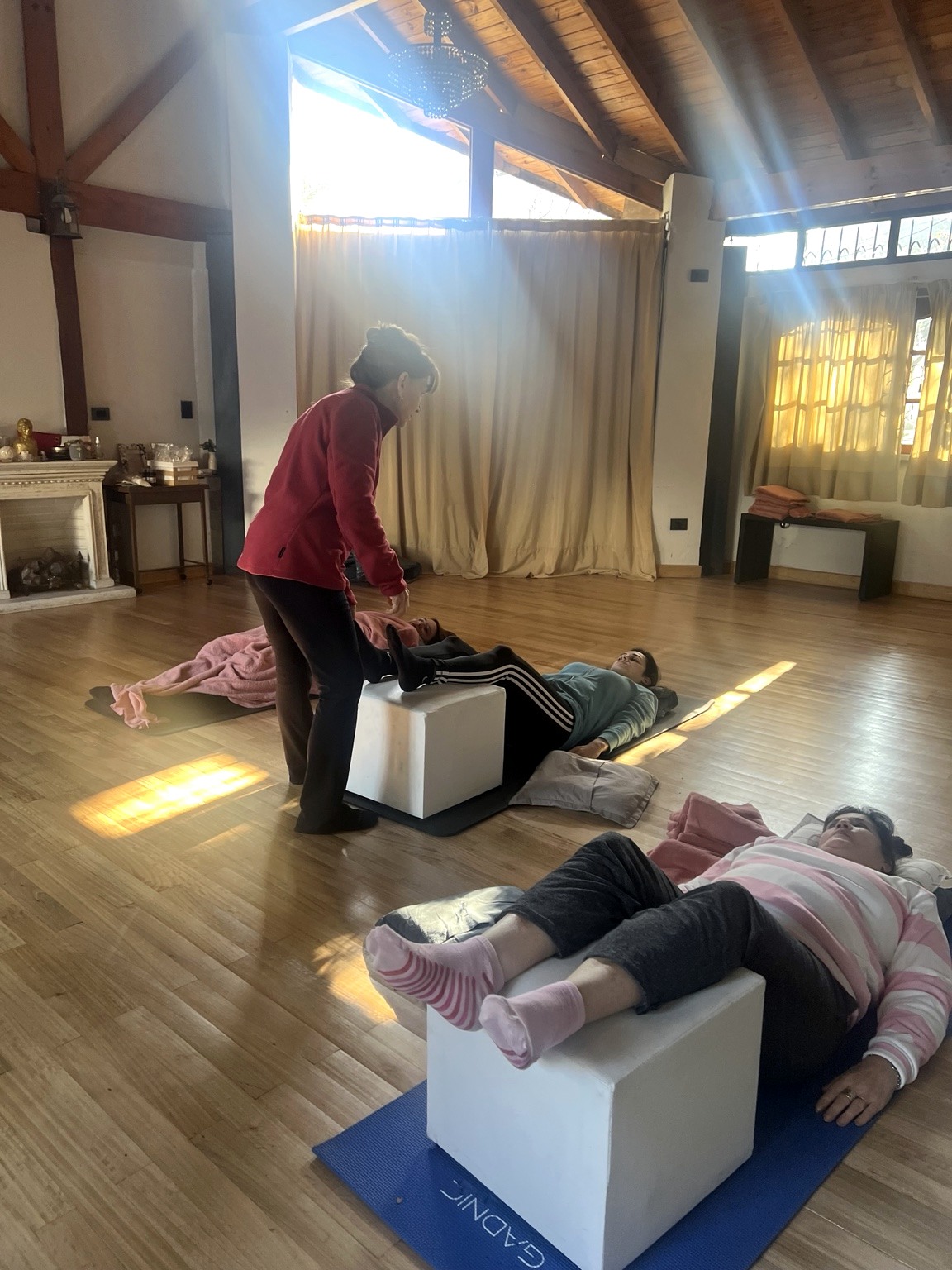 Alumnas practicando Yoga Regenerativo con apoyos, cubos y almohadones