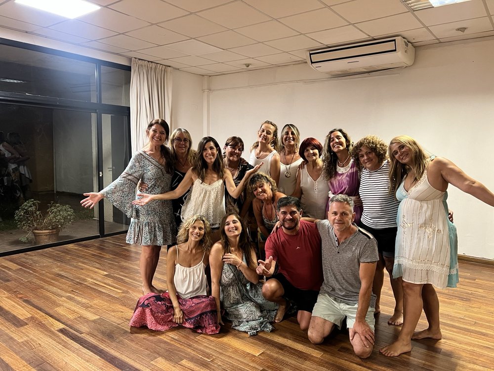 Grupo de participantes de un encuentro de Un Curso de Milagros, con los brazos abiertos